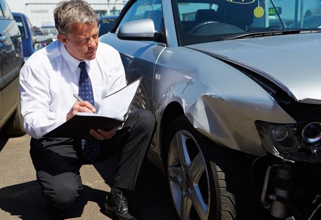 insurance claim form with car keys on desk